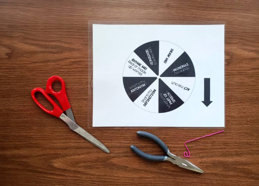 black and white word wheel on table with scissors and pliers